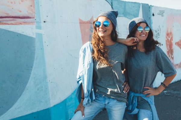 Models wearing plain tshirt and sunglasses posing over street wa